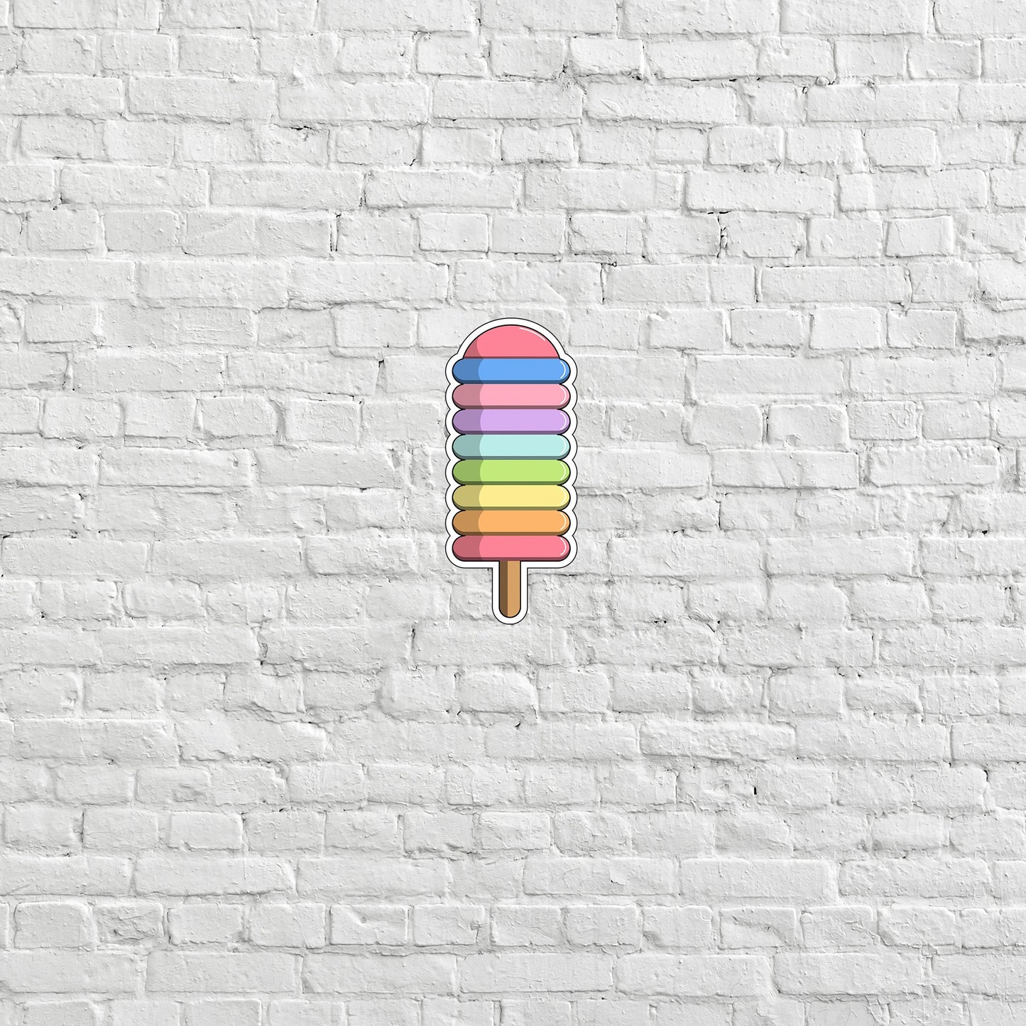 a colorful popsicle on a white brick wall