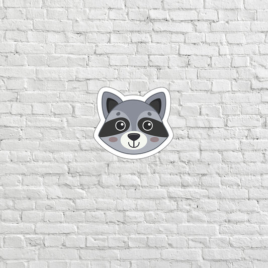 a raccoon sticker on a white brick wall