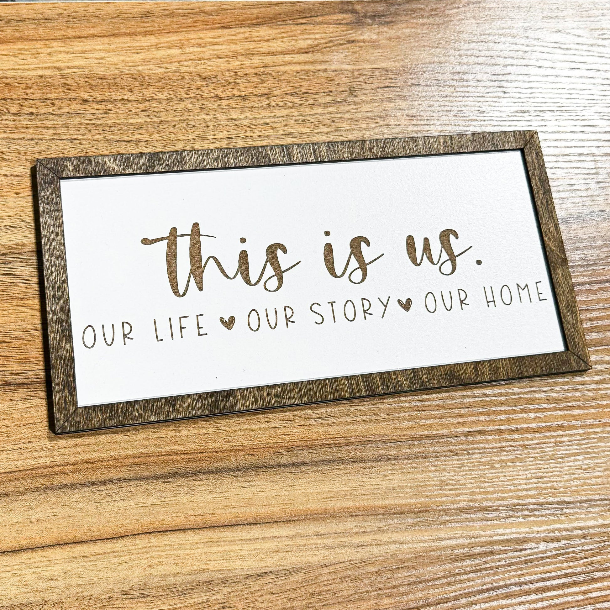 a wooden sign that says, this is us our life story our home